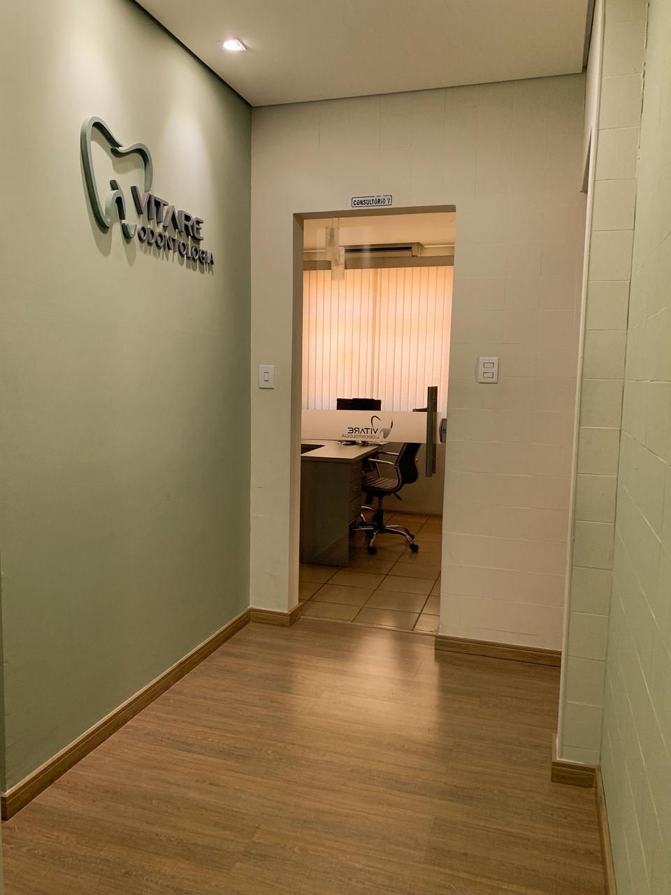 Recepção da Vitare Odontologia em Betim/MG com logo na parede verde